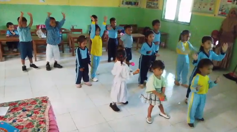 Anak-anak melakukan gerak dan lagu bersama di dalam kelas.